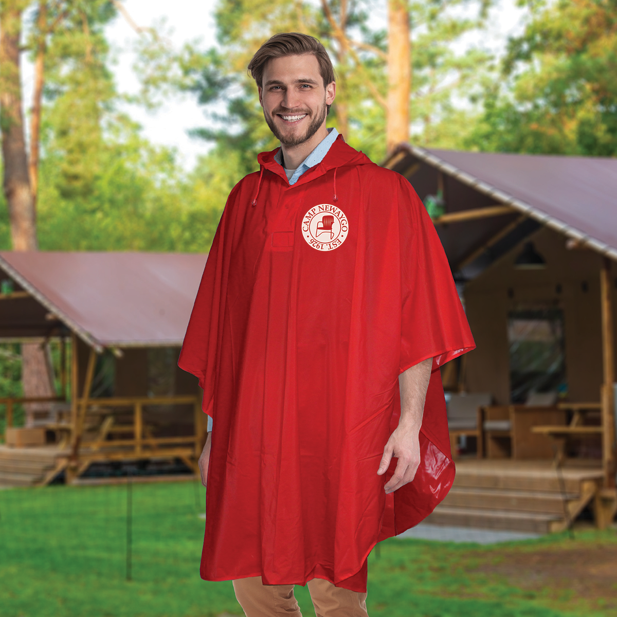 picture of man in red poncho with a logo on it and picnic shelters behind him